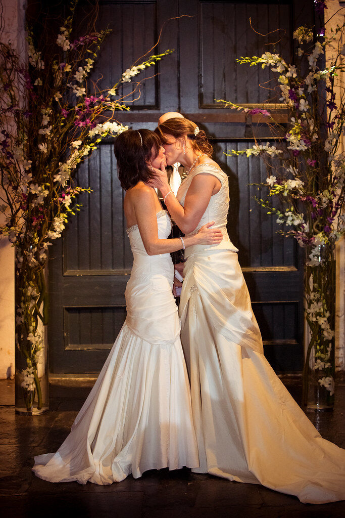 Bride and groom embrace on a boat during a sunny wedding day.