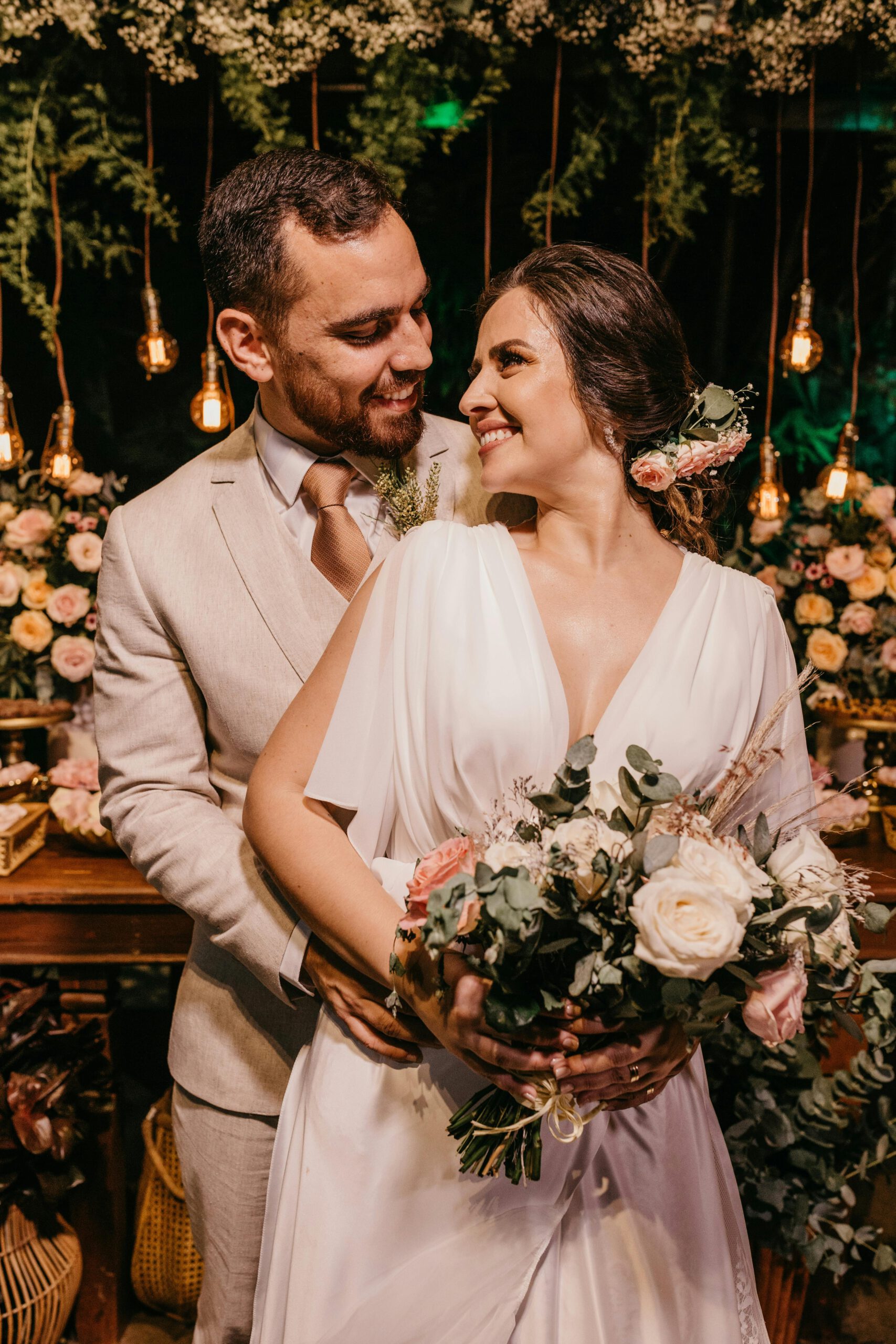 Bride and groom embrace on a boat during a sunny wedding day.